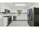 Bright kitchen featuring white cabinets, stainless steel appliances, and tile flooring at 4938 Cedar Lake Ter, Douglasville, GA 30135