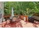 Spacious back deck with a table and chairs, surrounded by lush greenery and mature trees, perfect for outdoor dining at 1712 Grist Mill Dr, Marietta, GA 30062