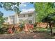 Exterior of the two-story home, showcasing the wooden deck with an outdoor dining area and a spacious backyard at 1712 Grist Mill Dr, Marietta, GA 30062