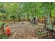 Large backyard featuring a fire pit, storage shed, and surrounded by mature trees at 1712 Grist Mill Dr, Marietta, GA 30062
