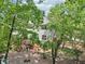 View of a home's backyard with a multi-tiered deck and a wooded yard with a fire pit at 1712 Grist Mill Dr, Marietta, GA 30062