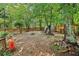View of the wooded backyard that has a storage shed, a fire pit and a swing set at 1712 Grist Mill Dr, Marietta, GA 30062