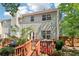 Exterior of the two-story home, showcasing the wooden deck with an outdoor dining area and a backyard at 1712 Grist Mill Dr, Marietta, GA 30062