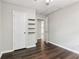 Bedroom featuring hardwood floors and white doors, one leading to the kitchen and shelves on the wall at 1712 Grist Mill Dr, Marietta, GA 30062