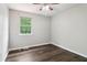 Bedroom features wood-look flooring, a bright window, and a ceiling fan with a light fixture at 1712 Grist Mill Dr, Marietta, GA 30062