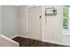 Entryway features wood floor, a white door, wall decorations, and natural light from the nearby window at 1712 Grist Mill Dr, Marietta, GA 30062