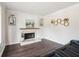 Bright living room showcasing white walls, a fireplace with a mantel, and dark wood floors at 1712 Grist Mill Dr, Marietta, GA 30062