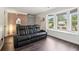 Stylish living room showcasing dark wood floors, a bay window, and a comfortable black leather sofa at 1712 Grist Mill Dr, Marietta, GA 30062