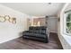 Cozy living room featuring a black sofa, dark wood floors, and a staircase leading to the upper level at 1712 Grist Mill Dr, Marietta, GA 30062