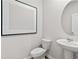 Neat bathroom features a pedestal sink, sleek round mirror, and modern fixtures at 2010 Moonlight Path, Covington, GA 30016