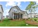 Charming home featuring a inviting front porch, a green lawn, and attractive flower beds at 2010 Moonlight Path, Covington, GA 30016