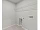A functional laundry room with essential hookups and wire shelving for organized storage at 2010 Moonlight Path, Covington, GA 30016