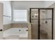Bathroom includes a soaking tub, tile surround, and glass shower at 2906 Jones Phillips Rd, Dacula, GA 30019
