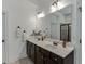 Modern bathroom with double sinks, quartz countertop, dark wood cabinets, and a large mirror at 2906 Jones Phillips Rd, Dacula, GA 30019