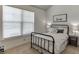 A bright bedroom features a comfy iron bed, a side table with a lamp, and natural light from a window at 2906 Jones Phillips Rd, Dacula, GA 30019