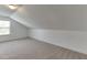Neutral bonus room featuring carpet, sloped ceilings, and natural light from a window at 2906 Jones Phillips Rd, Dacula, GA 30019