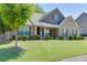 Well-maintained front yard features lush green grass, mature tree, and manicured shrubbery at 2906 Jones Phillips Rd, Dacula, GA 30019