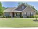 Charming brick home with a well-manicured front yard, lush green grass, and mature landscaping at 2906 Jones Phillips Rd, Dacula, GA 30019