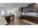 Contemporary kitchen with granite counters, dark wood cabinets, and stainless steel appliances at 2906 Jones Phillips Rd, Dacula, GA 30019