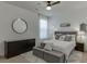 A spacious main bedroom boasts a plush bed, stylish dresser, modern round mirror, and ambient lighting at 2906 Jones Phillips Rd, Dacula, GA 30019