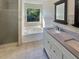 Bathroom featuring double vanity, tile floors, and a soaking tub under a window at 3479 Woodruff Ridge Ln, Loganville, GA 30052