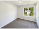 This bedroom has neutral paint, carpet, and natural light from the window at 3479 Woodruff Ridge Ln, Loganville, GA 30052