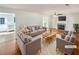 A bright and airy living room with hardwood floors, a fireplace, and neutral-toned furniture, virtually staged at 3479 Woodruff Ridge Ln, Loganville, GA 30052