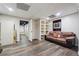Finished basement with wood flooring, a comfortable sofa, and built-in shelving for entertainment or storage at 3725 Falls Trl, Winston, GA 30187