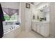 Bathroom with large tub, white cabinets, and natural light from the window at 3725 Falls Trl, Winston, GA 30187