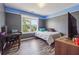 Well-lit bedroom has wood floors, large window, desk, and modern decor at 3725 Falls Trl, Winston, GA 30187