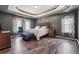 Comfortable main bedroom featuring tray ceilings, hardwood floors, and relaxing ambiance at 3725 Falls Trl, Winston, GA 30187