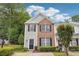 Charming two-story townhome featuring brick and gray siding, complemented by manicured landscaping and black shutters at 9165 Nesbit Ferry Rd # 9, Alpharetta, GA 30022