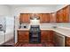 Galley kitchen featuring stainless steel appliances, wooden cabinets, and stone countertops at 9165 Nesbit Ferry Rd # 9, Alpharetta, GA 30022