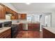 Stylish kitchen with hardwood floors, dark wood cabinetry, and stainless steel appliances, open to the living space at 9165 Nesbit Ferry Rd # 9, Alpharetta, GA 30022