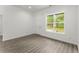 A bright bedroom with wood-look flooring and a large window at 110 Beaver Pointe, Villa Rica, GA 30180