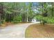 Long driveway leading to a charming home surrounded by lush trees and greenery at 110 Beaver Pointe, Villa Rica, GA 30180
