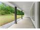 Covered porch with grey columns and wood-look flooring overlooking a lawn and forest at 110 Beaver Pointe, Villa Rica, GA 30180