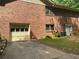 Brick home featuring an attached garage and exterior door, set against a vibrant green backdrop at 19 Margrit Ct, Stockbridge, GA 30281