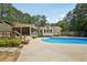 Lush backyard featuring a pool, cozy screened porch, and wood privacy fence at 19 Margrit Ct, Stockbridge, GA 30281
