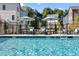 Community pool featuring lounge chairs and patio umbrellas with a glimpse of surrounding residential buildings at 3316 Stillwood Ln, Atlanta, GA 30354