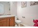 Powder room with vanity, toilet, floral decor, and neutral color palette at 35 Kendall Ln, Covington, GA 30014