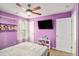 Bedroom with purple walls, a ceiling fan, TV, and bed at 35 Kendall Ln, Covington, GA 30014