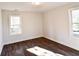 A bedroom featuring wood-look flooring, fresh white walls, and natural light from two windows at 3601 Orchard Cir, Decatur, GA 30032