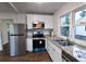 The home features a bright kitchen with stainless steel appliances, granite counters, and laminate floors at 3601 Orchard Cir, Decatur, GA 30032