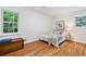 Bright bedroom with wood floors, a bed with a blue throw, and a trunk at 3521 Eaglerock Dr, Atlanta, GA 30340