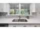 Kitchen sink features stainless steel fixtures, quartz countertops, mosaic tile backsplash, and natural light at 3521 Eaglerock Dr, Atlanta, GA 30340