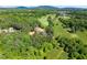 A beautiful aerial view of the home nestled among the green trees and a meadow in the background at 3805 Carder Ln, Cumming, GA 30028