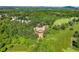 An aerial view shows the home nestled amongst the trees with green fields surrounding it at 3805 Carder Ln, Cumming, GA 30028