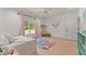 Bright bedroom with wood floor, ceiling fan, large window, and colorful rug at 3805 Carder Ln, Cumming, GA 30028