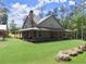 Home features a covered porch that wraps around the side, overlooking the well manicured lawn at 3805 Carder Ln, Cumming, GA 30028